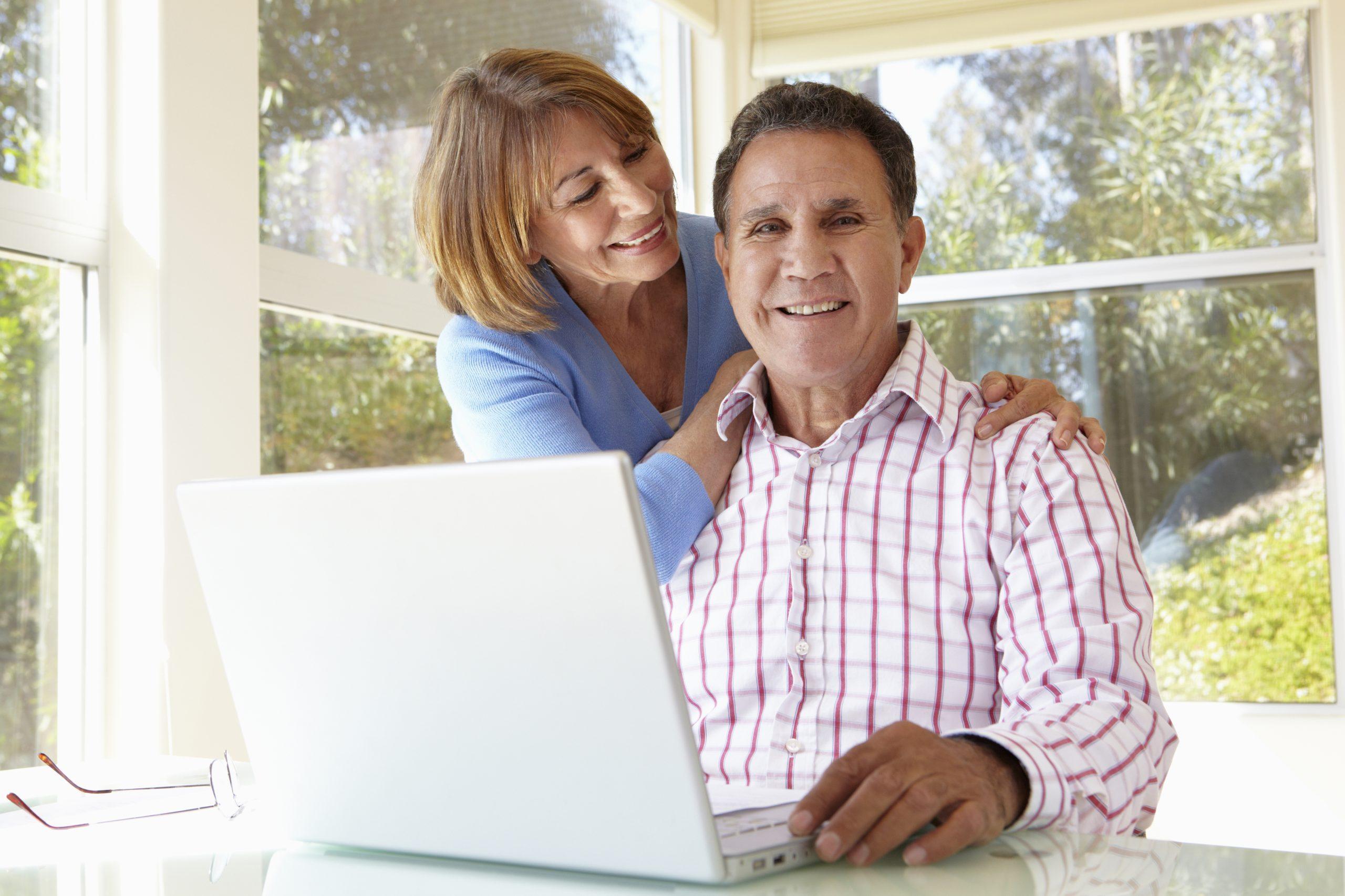Elderly couple using laptop in Central California home