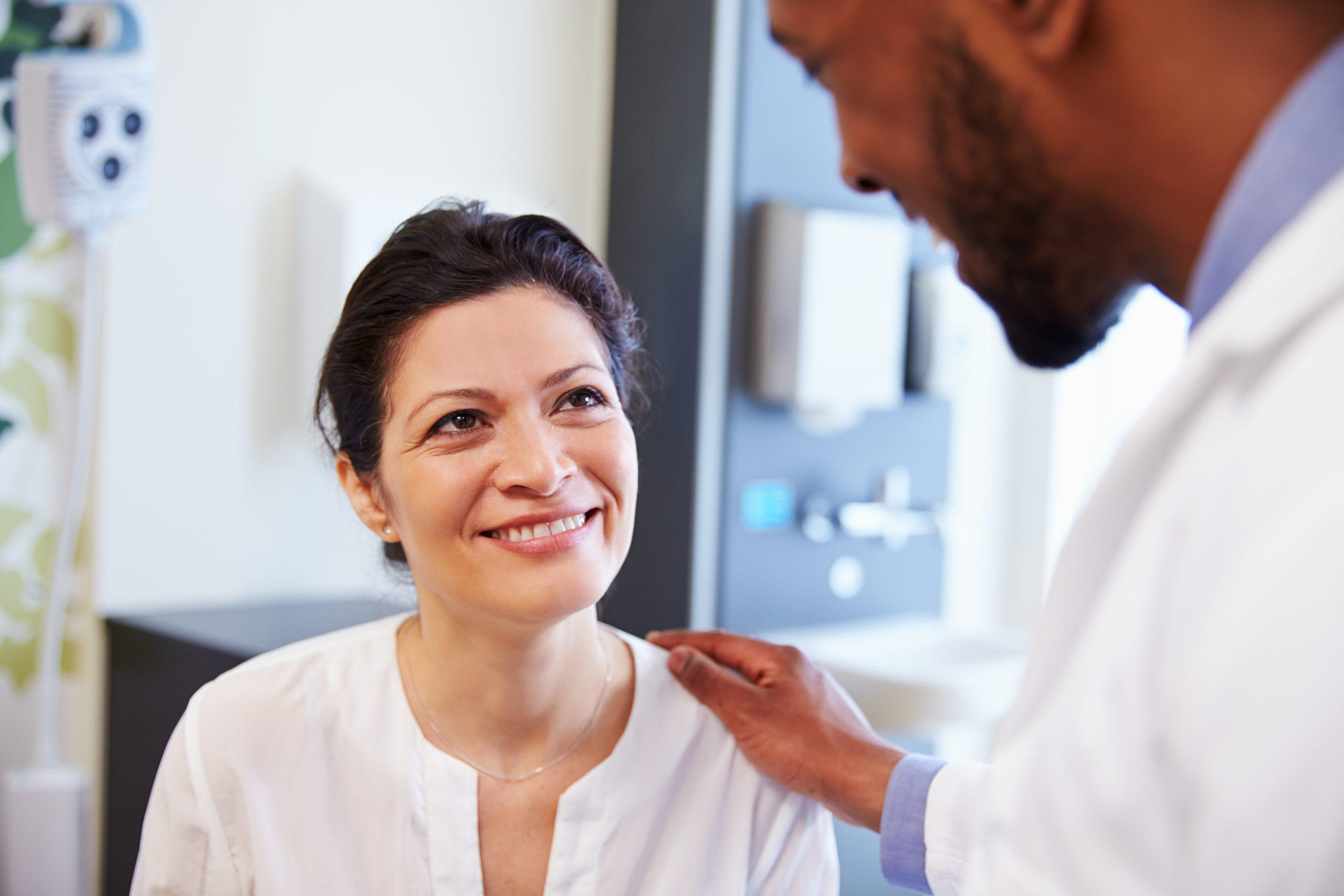 Medical personell talking to a smiling woman