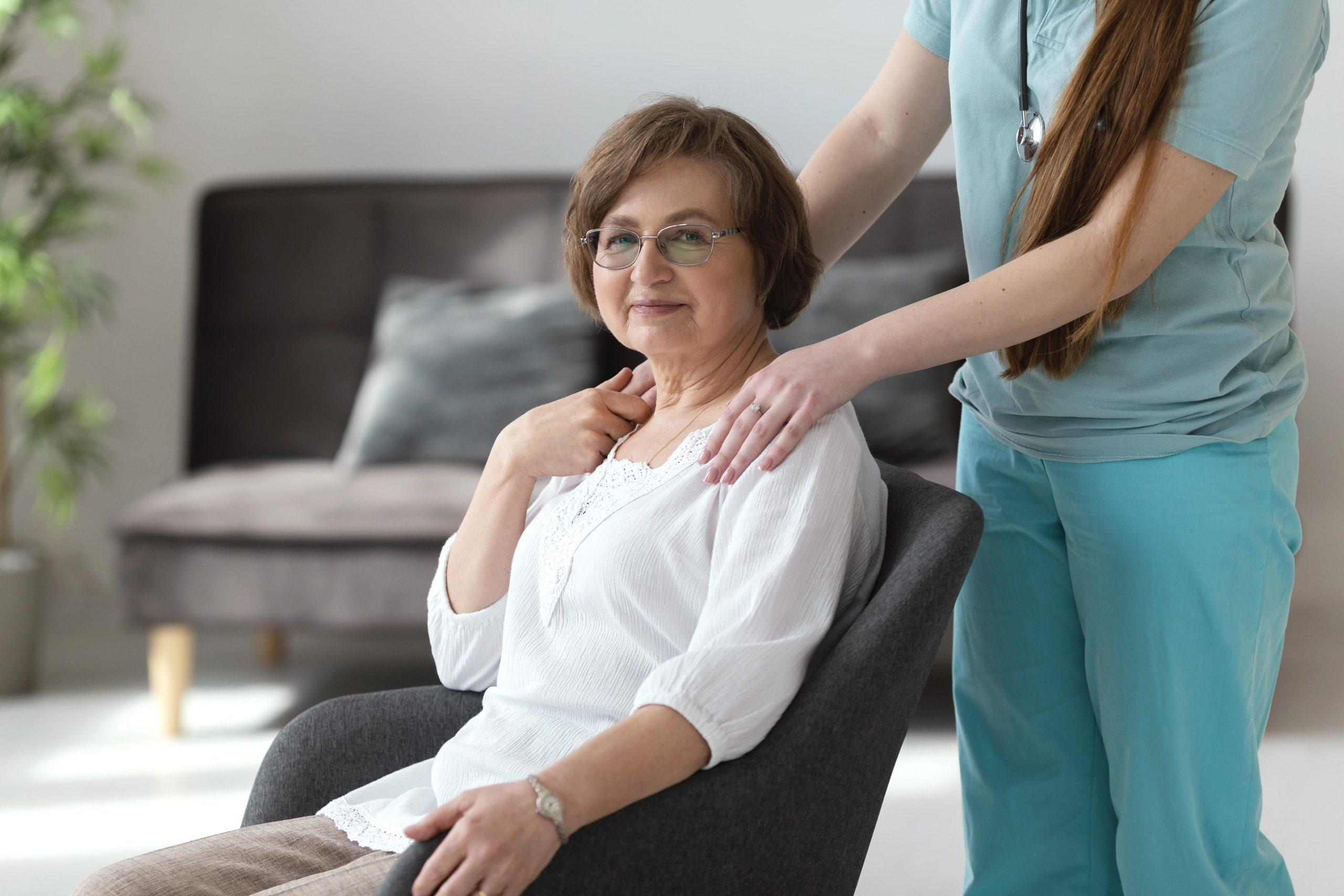Medical professional holding shoulders of woman in chair