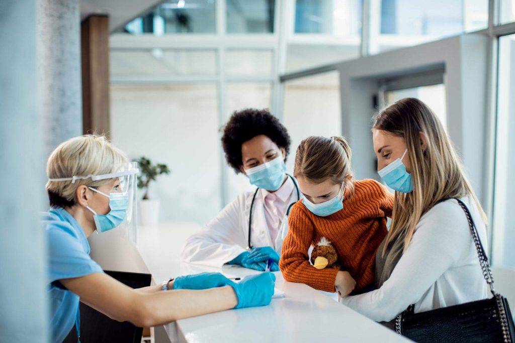 Woman and mother look at a paper with medical professionals